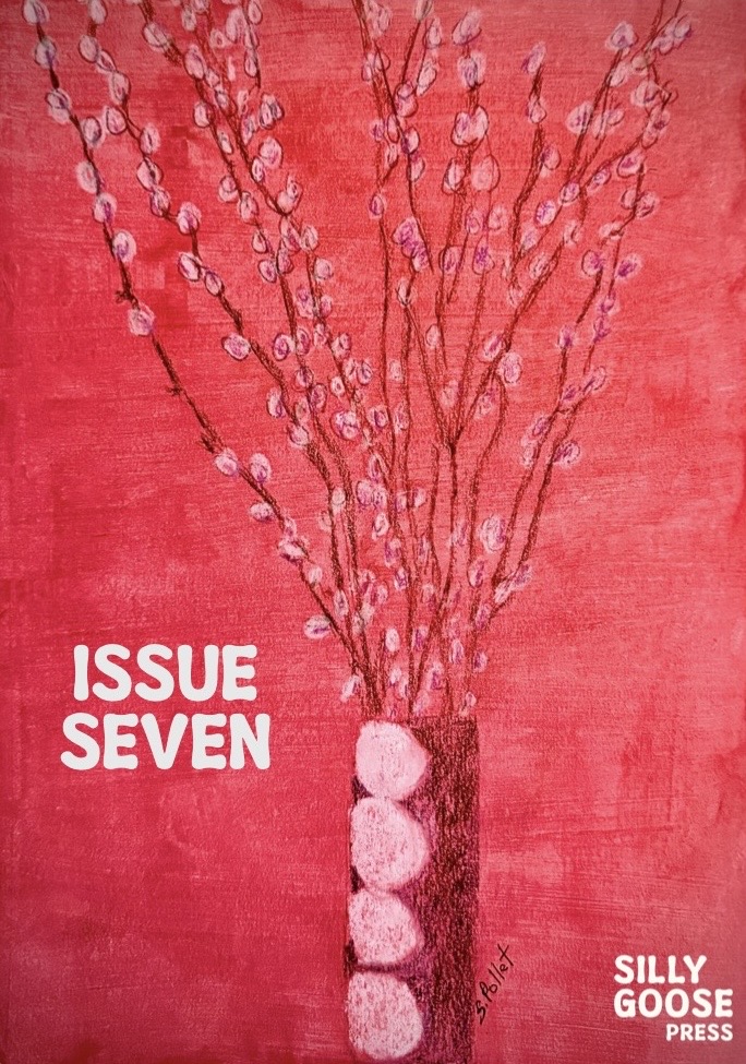 a red vase of pussywillow branches